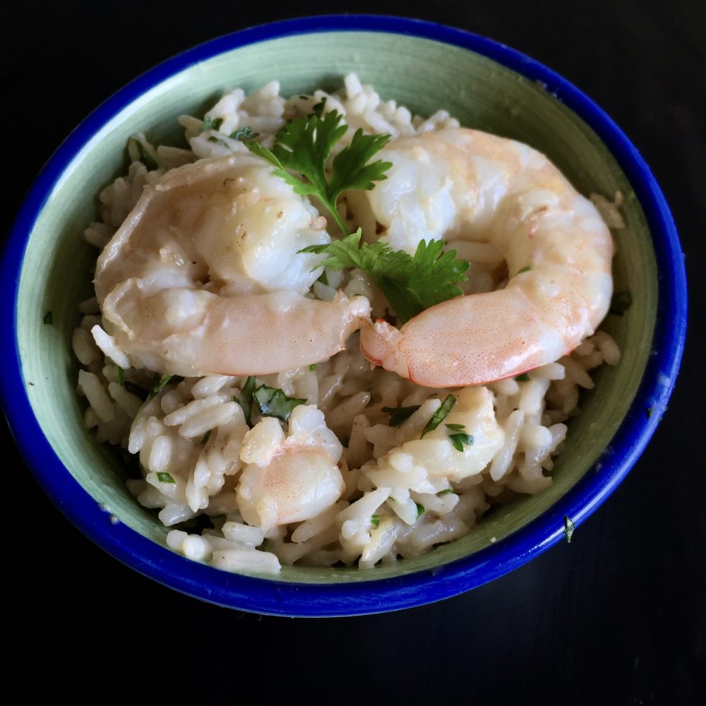 This Thai style full of flavour creamy coconut rice with a hint of kaffir lime leave and chopped coriander stir through not forgetting the pieces of prawn meat and 2 whole prawns placed on top with a sprig of coriander for garnish. Served in a royal blue rimmed bowl . Enjoy!