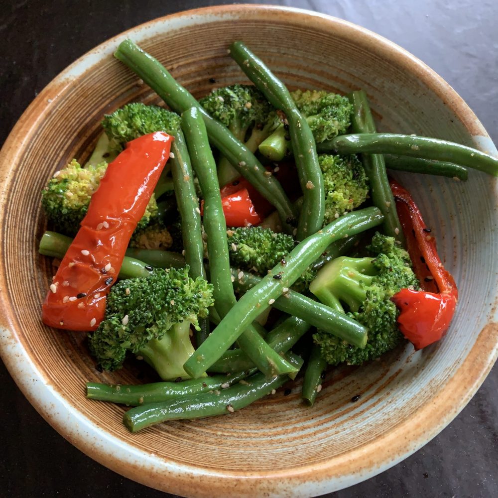 Sesame Beans and Broccoli Salad: A small bowl filled with fresh broccoli, green beans and red capsicum coated with white and black sesame seeds and dressed in a combination of sesame oil, vinegar, soy sauce and extra virgin olive oil by cookingmealsforone.com